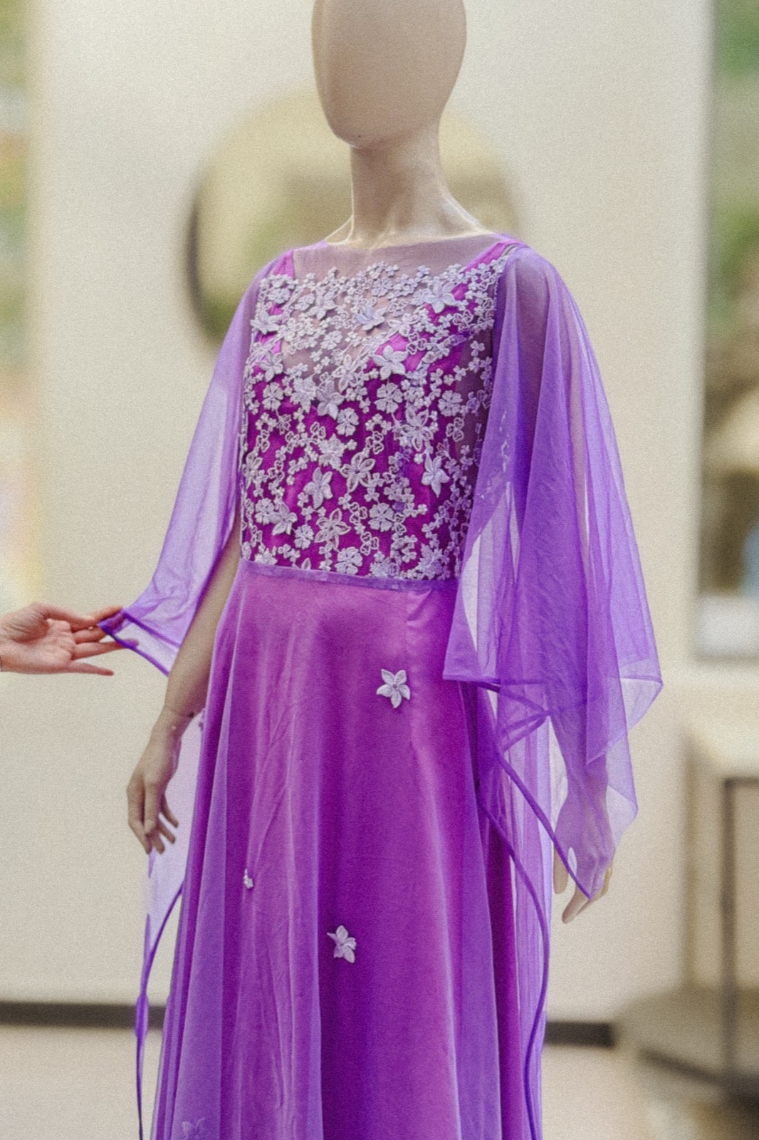Detalle del bordado floral del corpiño violeta amatista de Atelier Molina, sobre maniquí con las mangas de organza extendidas.