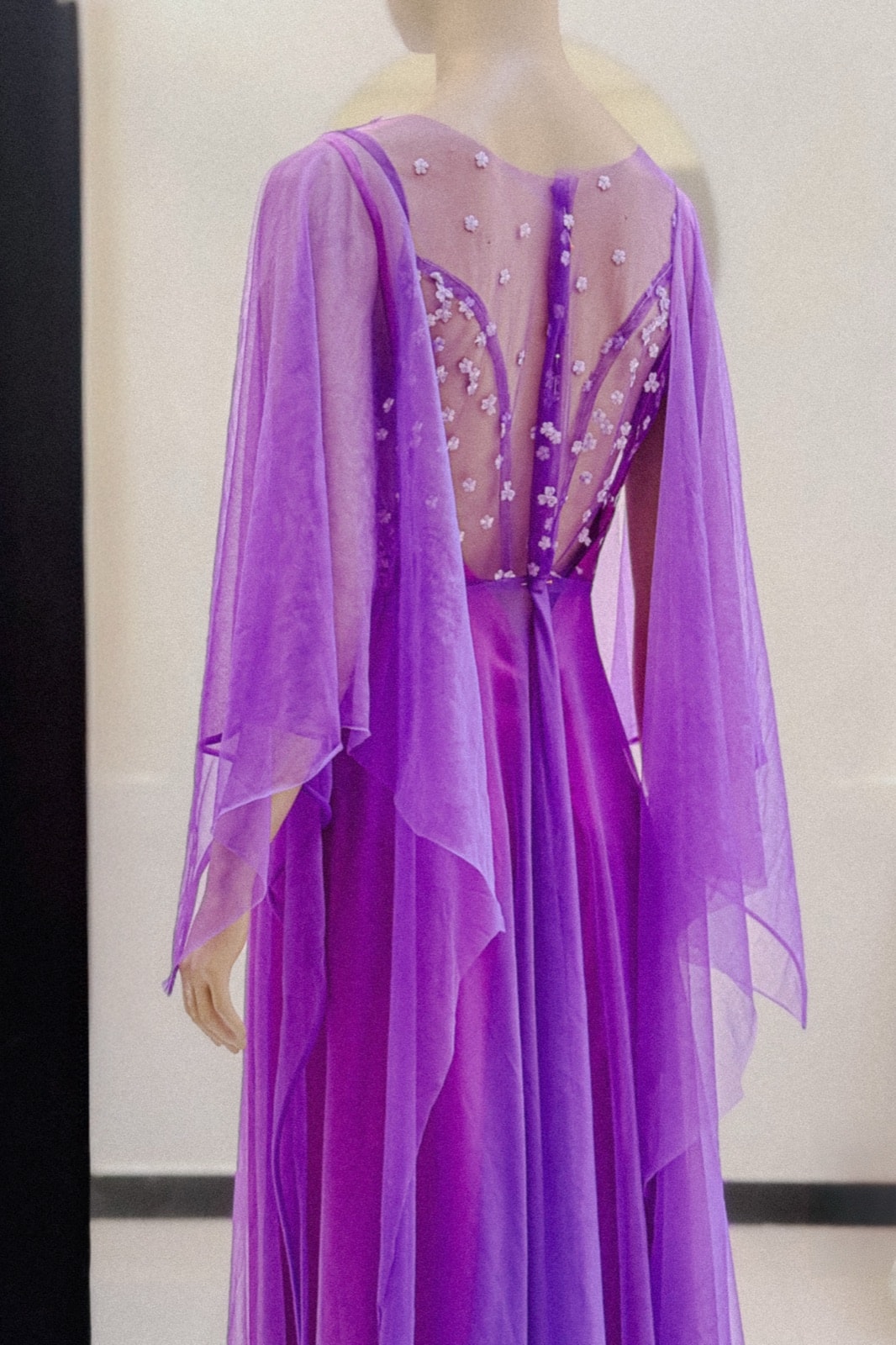 Detalle de la espalda transparente con bordado floral del vestido violeta amatista de Atelier Molina, sobre maniquí.