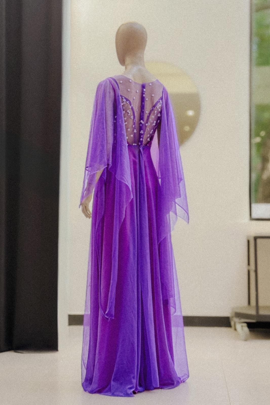 Espalda del vestido largo violeta amatista de Atelier Molina sobre maniquí, con la falda de tul plisado hasta el piso.
