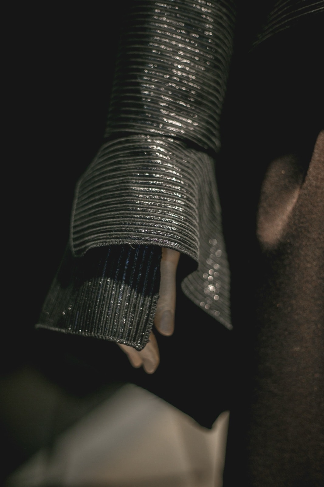 Detalle del puño texturizado de la Blusa Olé! Negra Texturizada, con la mano del maniquí asomando bajo la tela.