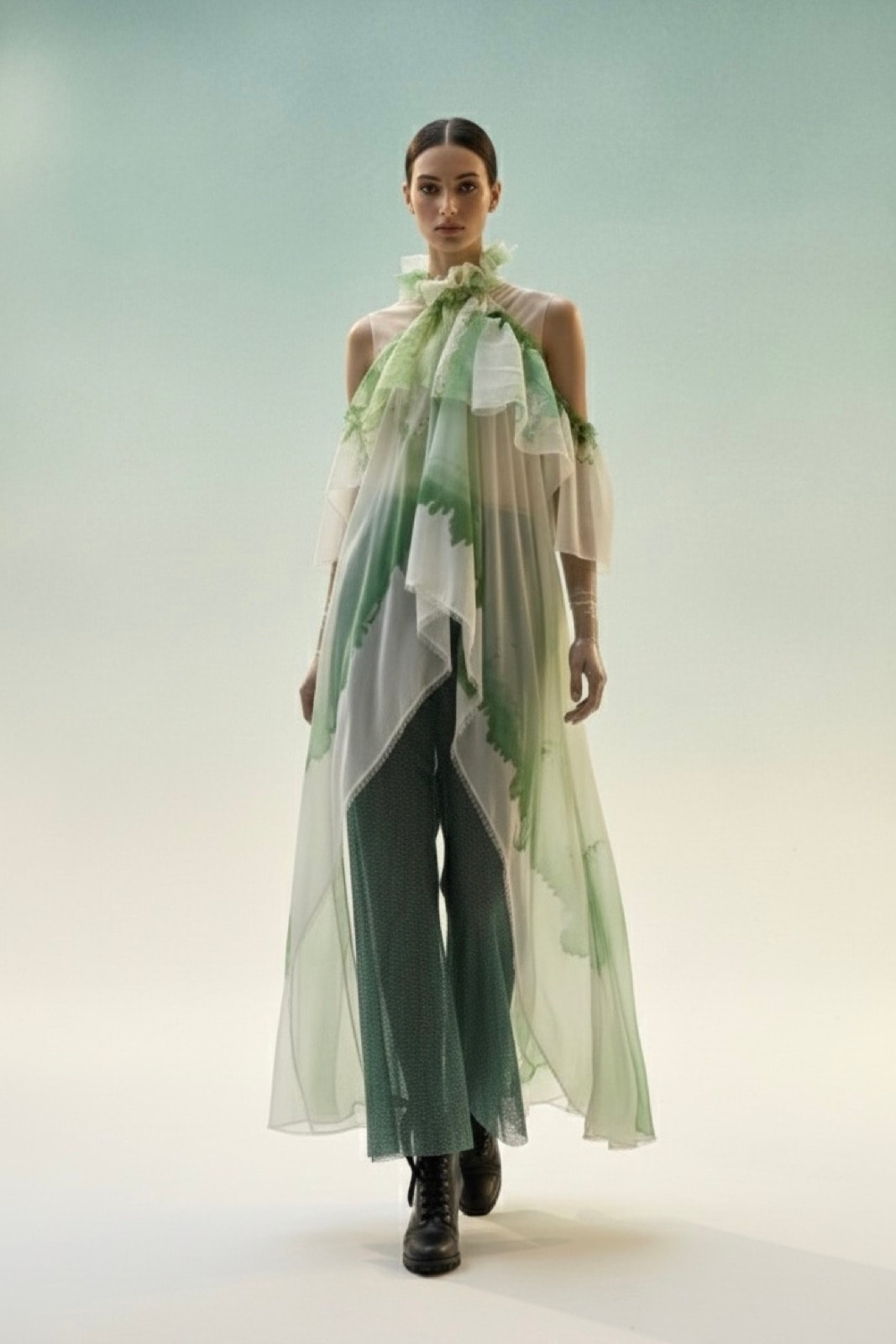 Blusa Olé! Verde sobre modelo caminando de frente, con la caída completa de la gasa de seda hasta el largo maxi.