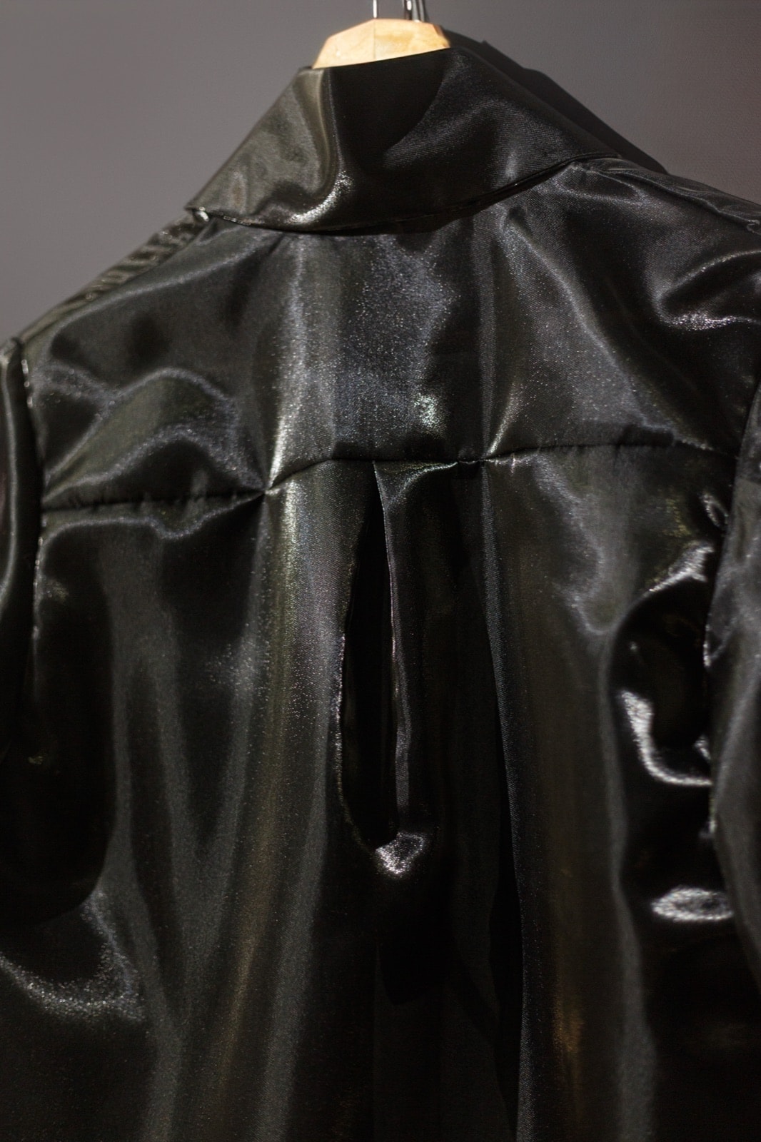 Detalle del pliegue central en la espalda de la Camisa de organdí negra de Atelier Molina, colgada en percha.