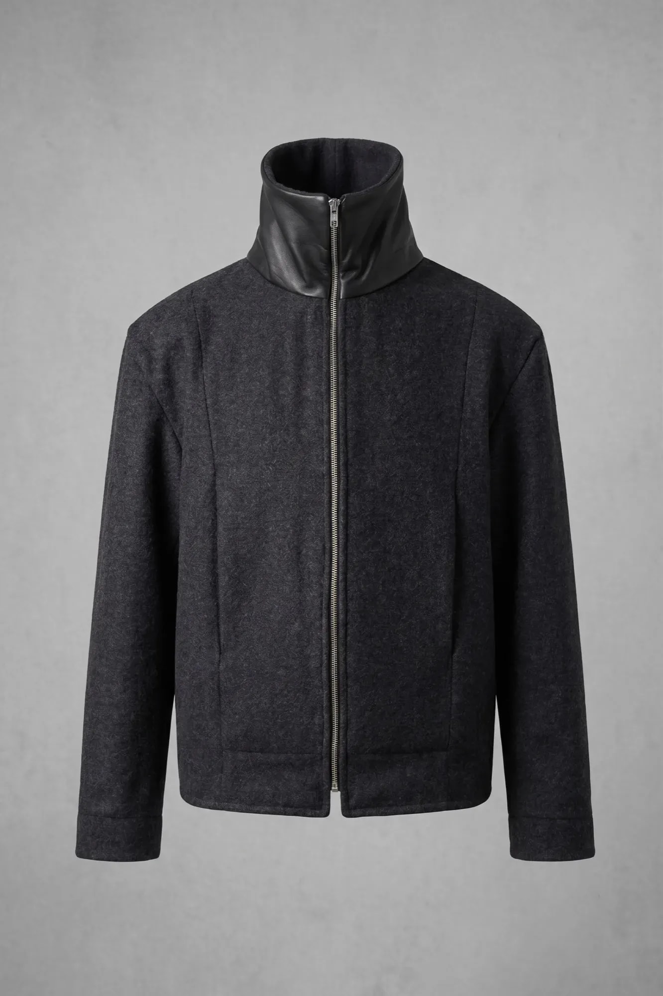 Chaqueta de lana prensada gris de Atelier Molina sobre modelo, vista frontal con el cierre cerrado hasta el cuello de napa.