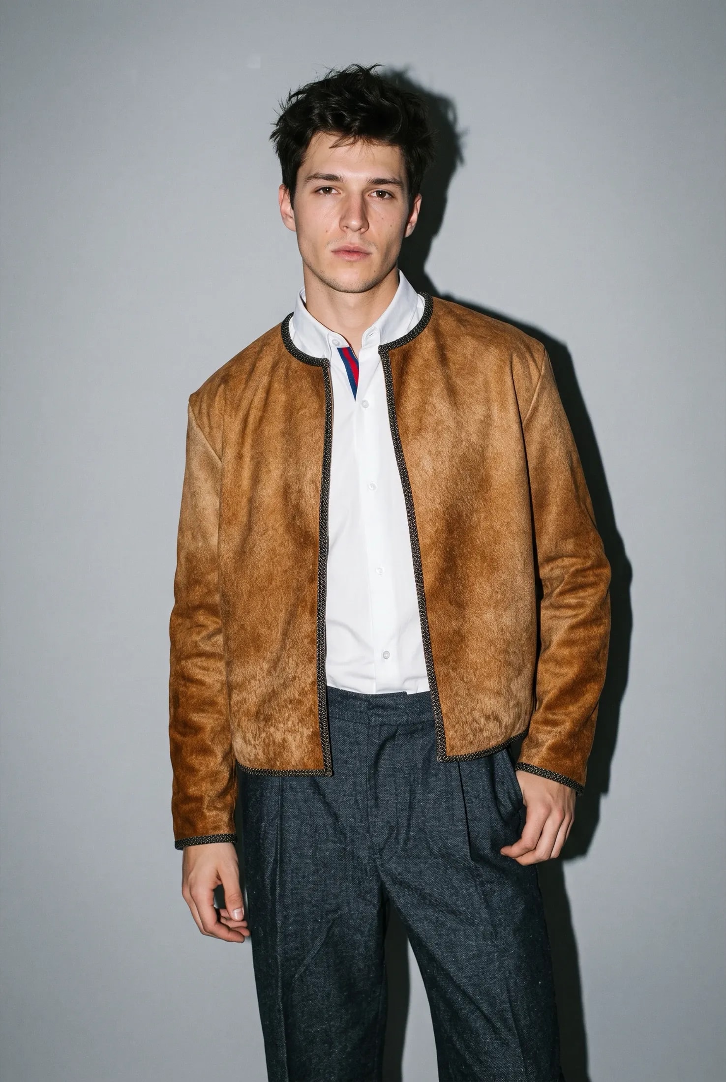 Chaqueta corta de cuero vacuno con pelo color caramelo, frente abierto y bies a tono, sobre camisa blanca, de frente. Atelier Molina, Buenos Aires