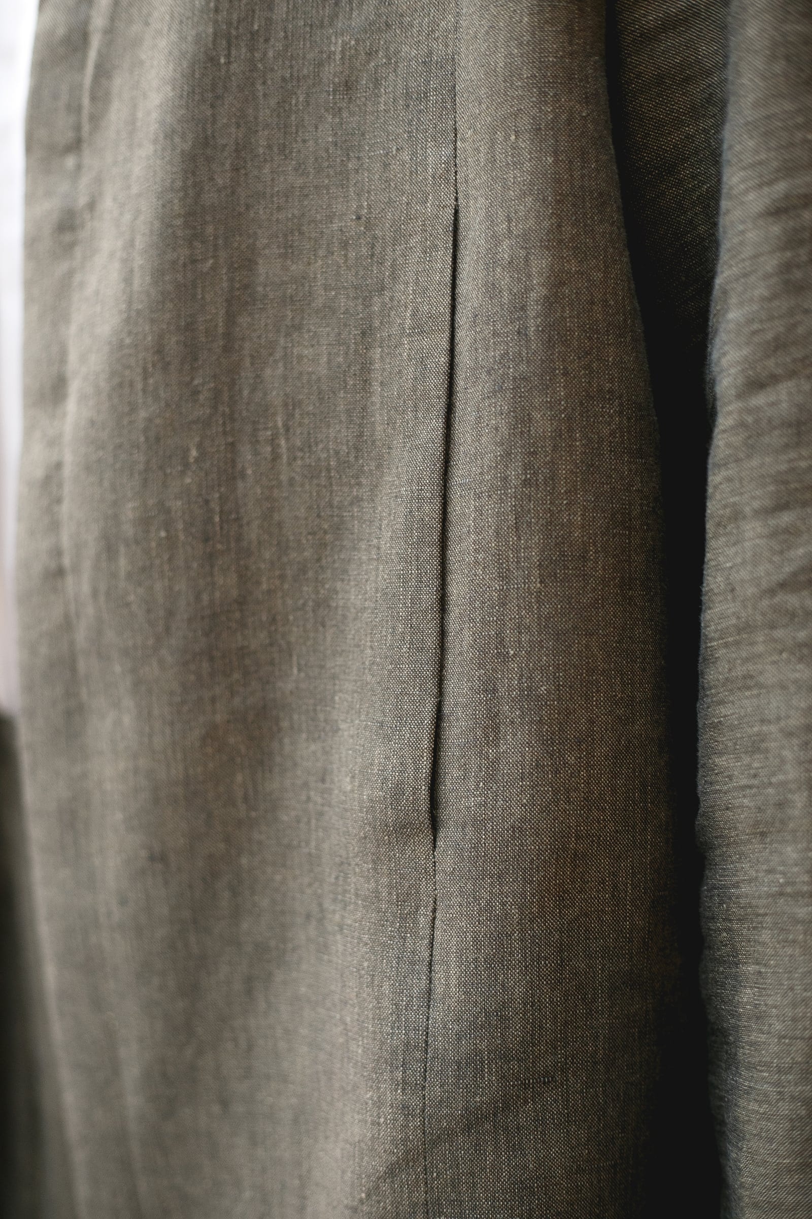 Primer plano de una pinza vertical en la espalda de la chaqueta de lino italiano, mostrando la estructura del tejido de 245 g/m².