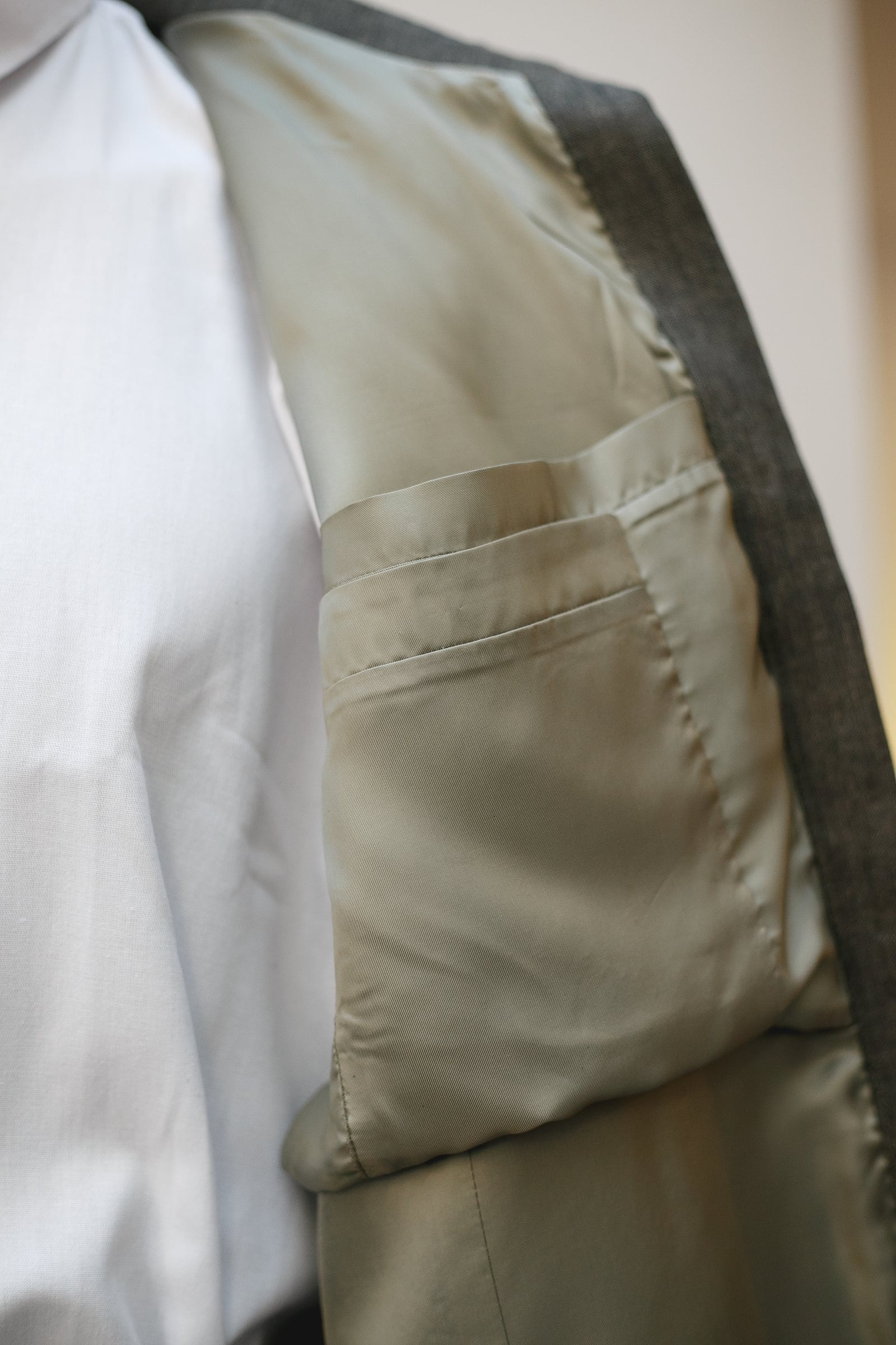 Interior de la chaqueta de lino italiano abierta, con el forro de cupro Bemberg verde y el bolsillo interior con vivo.