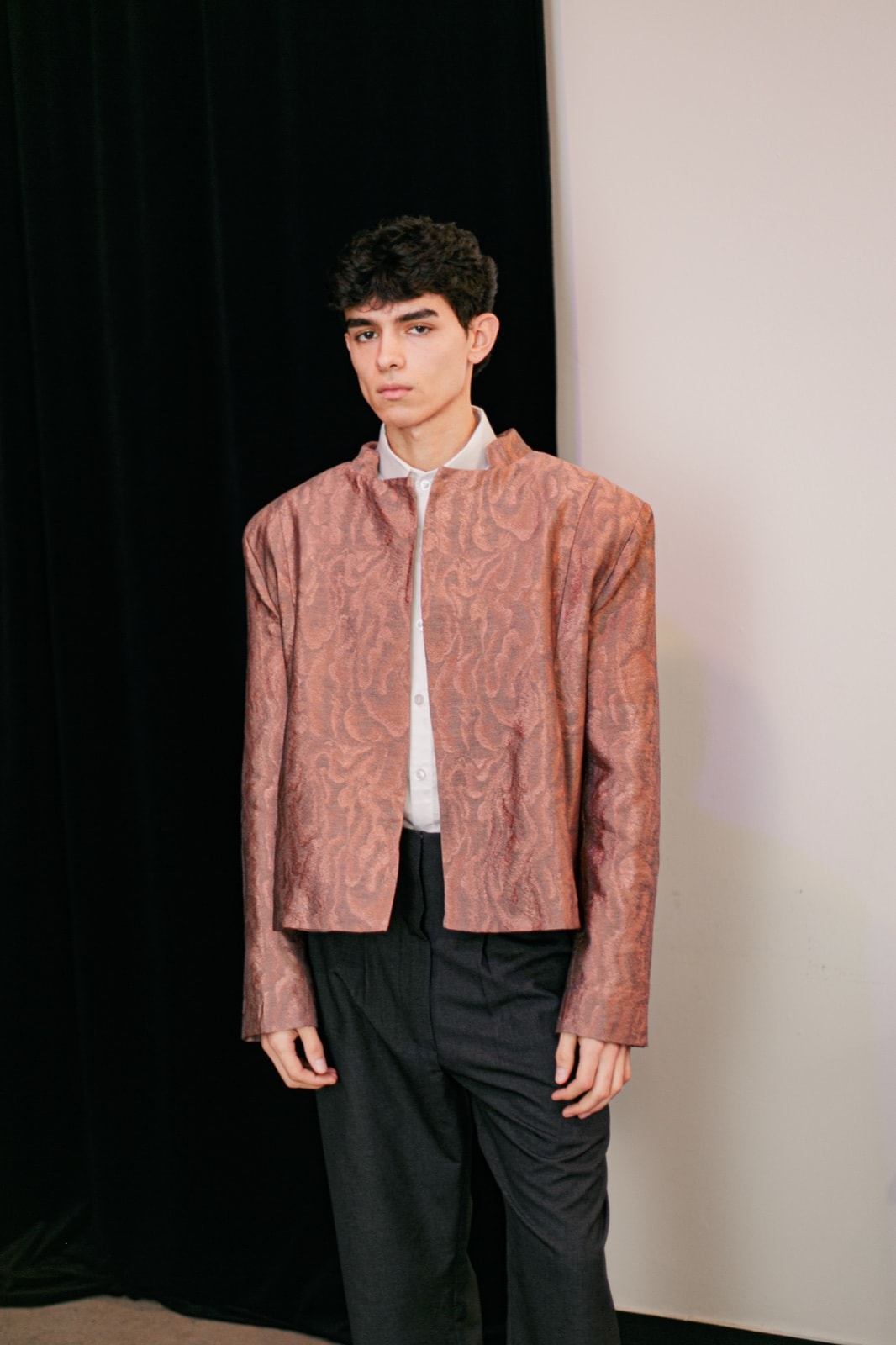 Chaqueta de jacquard rosa con vetas grises, cuello mao alto y hombros marcados, usada abierta sobre camisa blanca y pantalón gris. Atelier Molina, Buenos Aires
