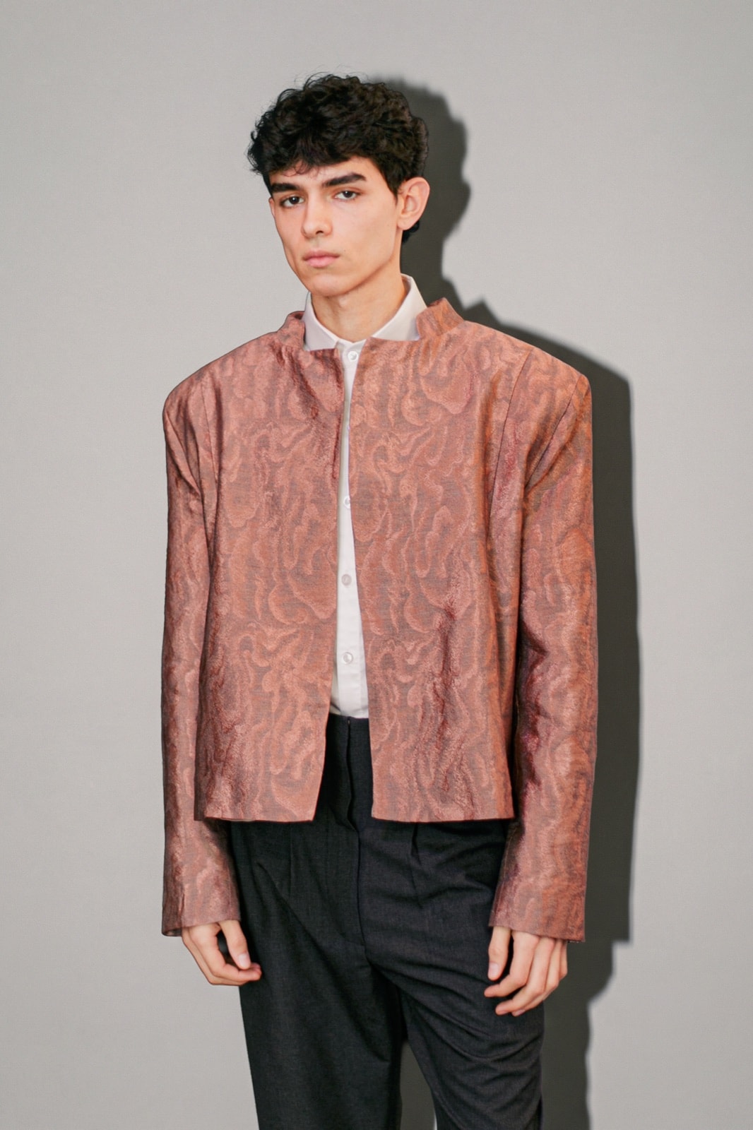 Chaqueta de jacquard rosa de largo corto y manga recta, vista de frente sobre fondo gris. Atelier Molina, Buenos Aires