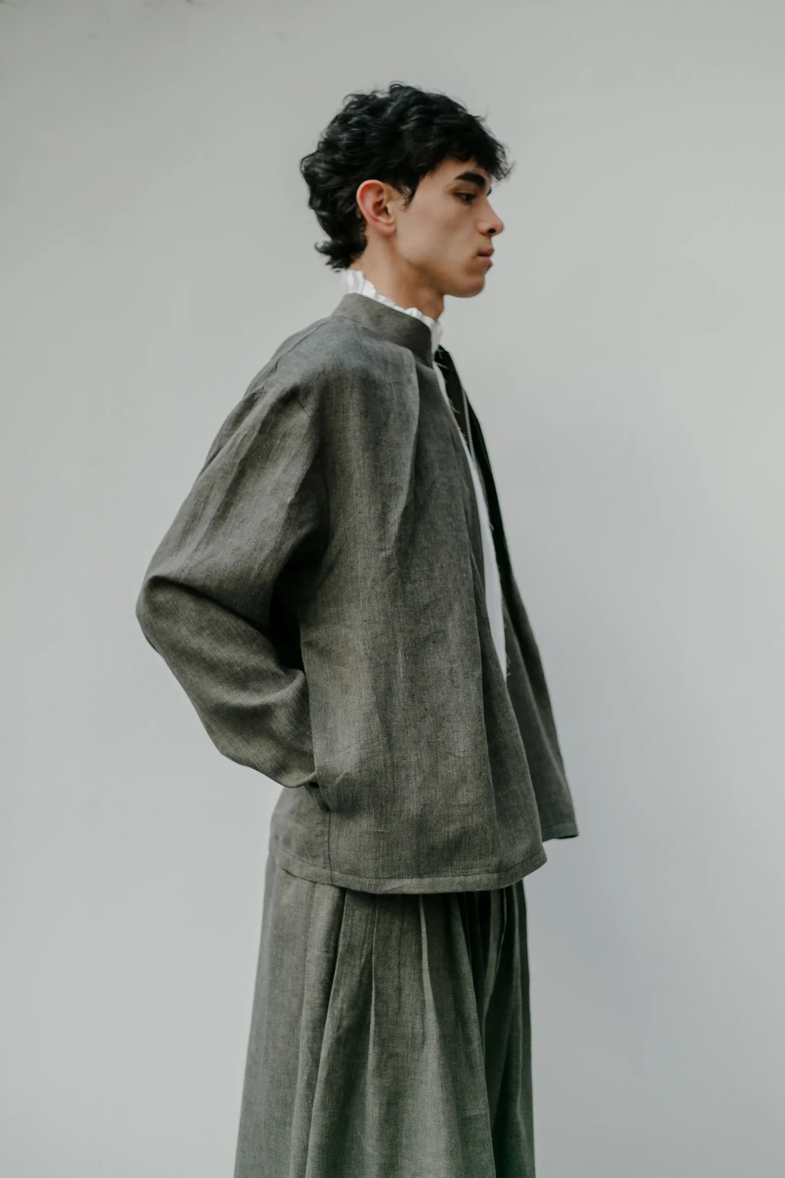Chaqueta Molina de lino italiano verde alga vista de perfil, con el volumen del cuerpo boxy y la manga amplia de caída recta. Atelier Molina, Buenos Aires