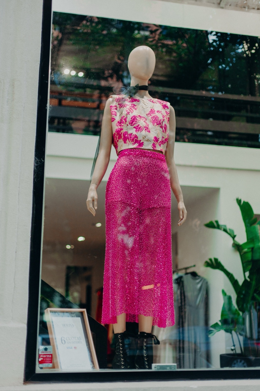 Falda de canutillos y lentejuelas fucsia en la vidriera del atelier en Buenos Aires, combinada con top jacquard floral.