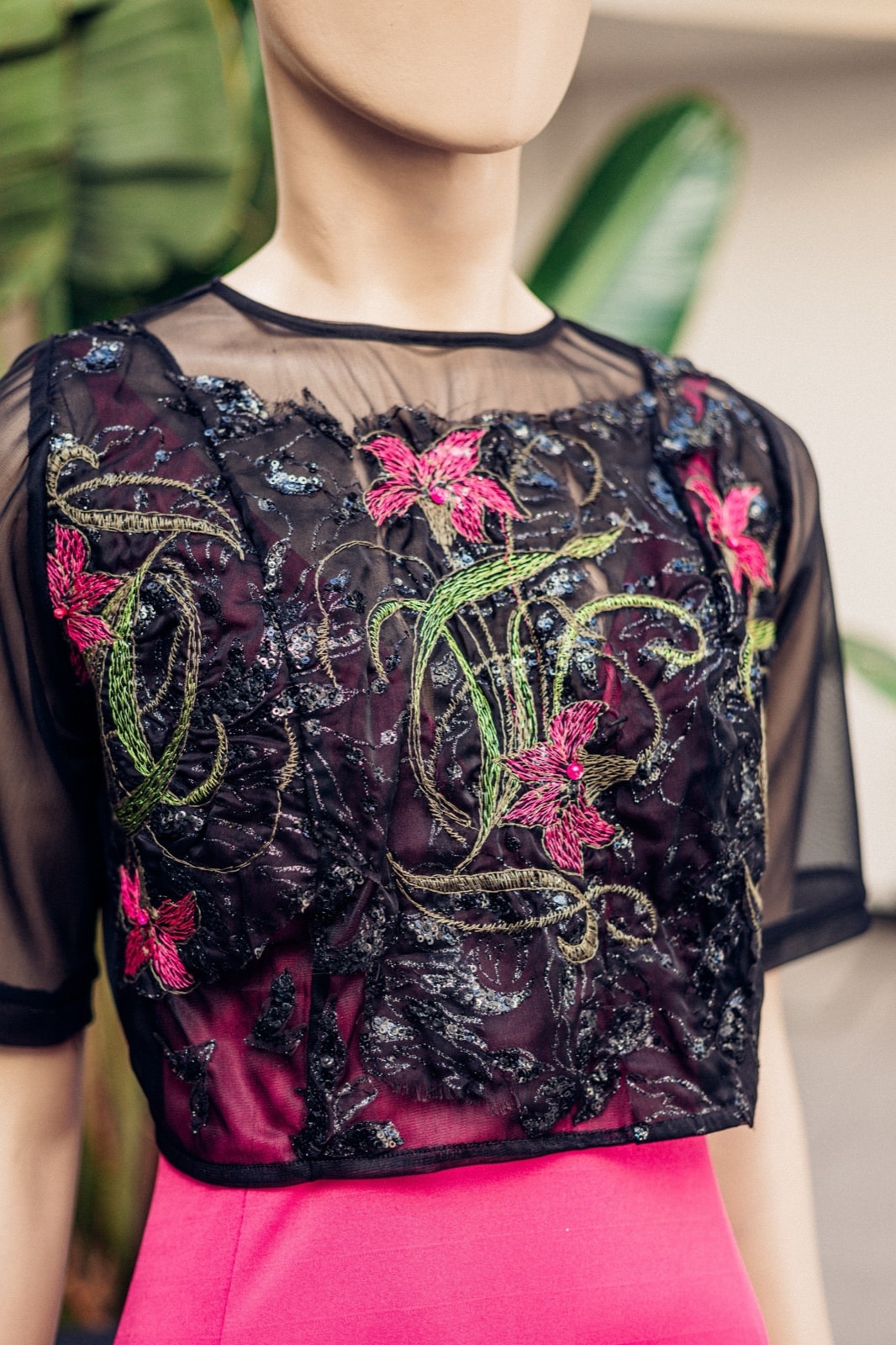 Croptop Garden Night sobre maniquí con plantas de fondo, vista frontal cercana que muestra el bordado completo del cuerpo.