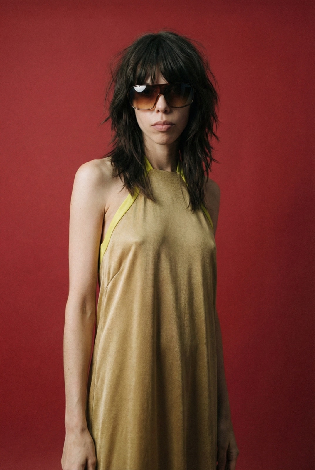 Golden Lime Dress, detalle del escote halter con vivo lima sobre crepe satén dorado, primer plano de modelo.
