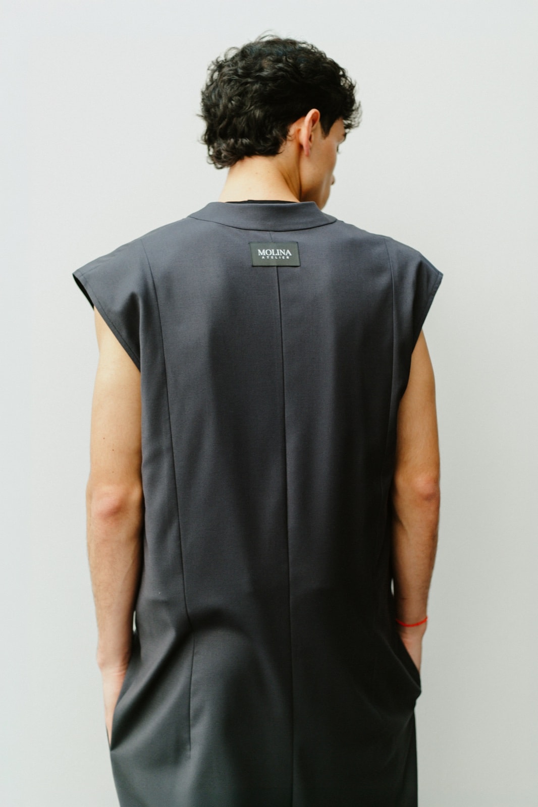 Detalle de la espalda del jumpsuit sastrero gris con la etiqueta Molina Atelier.
