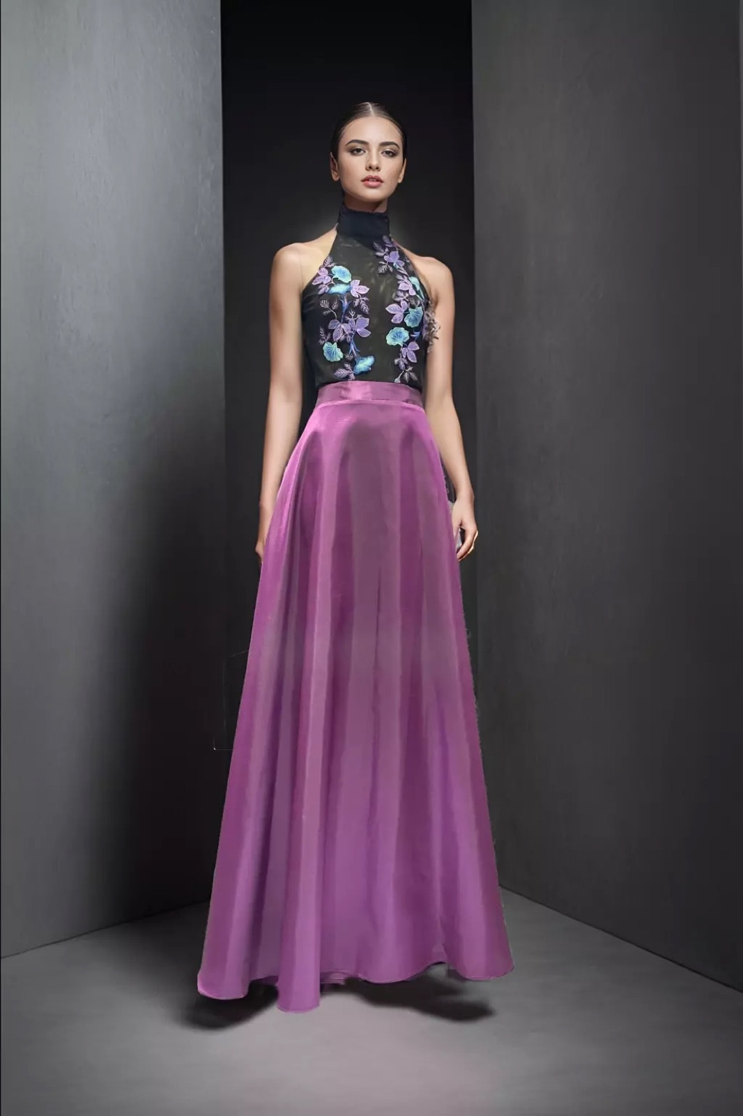Maxi-falda de tafetán de seda color magenta de Atelier Molina, sobre modelo con top halter bordado, fondo gris de estudio.