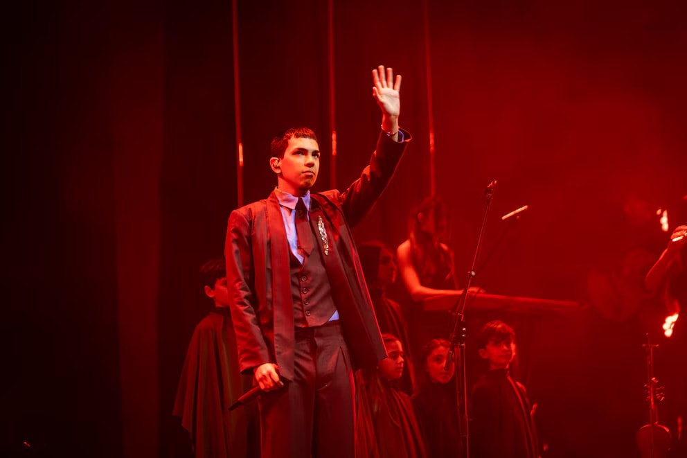 Milo J在Gardel Awards现场表演，在红灯下穿着工作室量身定制的西装