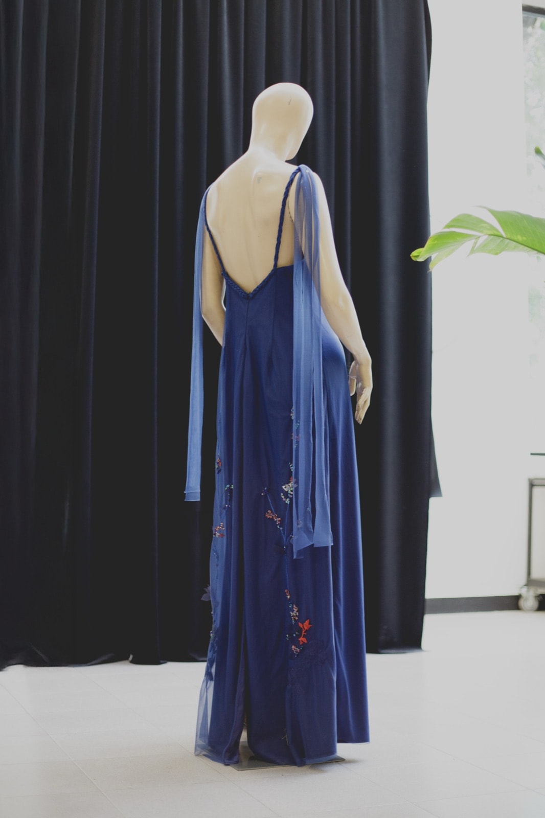 Nigh Blue Garden Dress, vista de espalda completa sobre maniquí, con el bordado floral asomando en la falda.