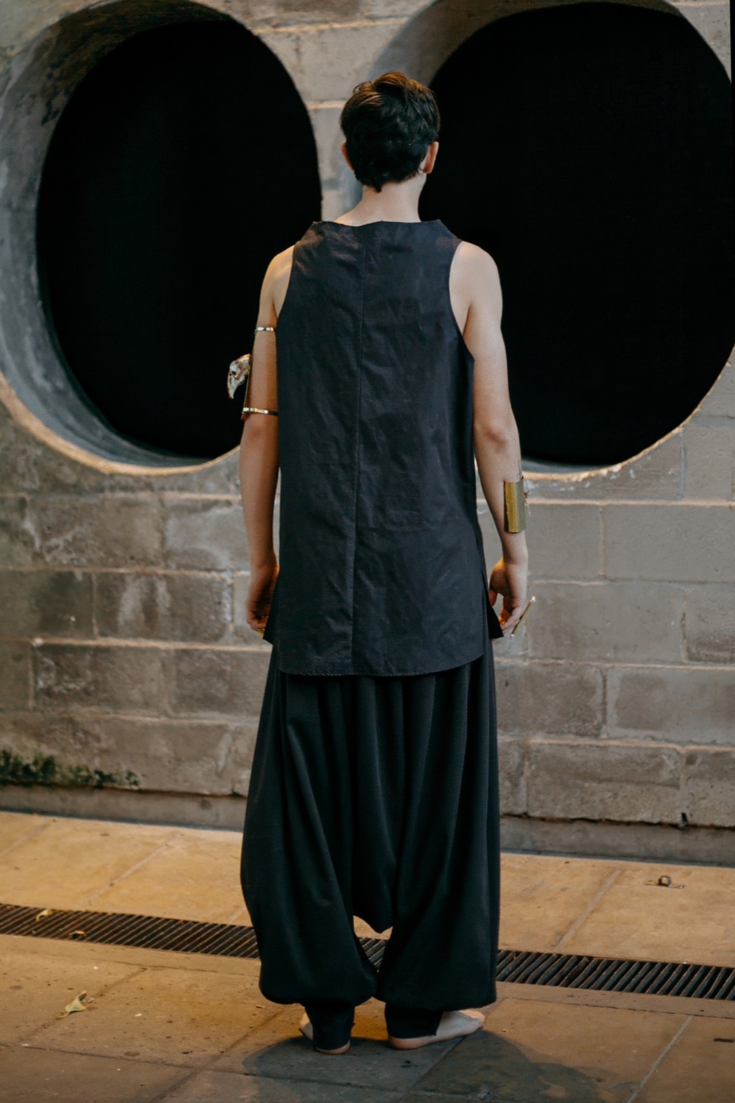 Pantalón chiripá gris oscuro de Atelier Molina sobre modelo, vista de espalda mostrando la caída suelta sobre la pierna.