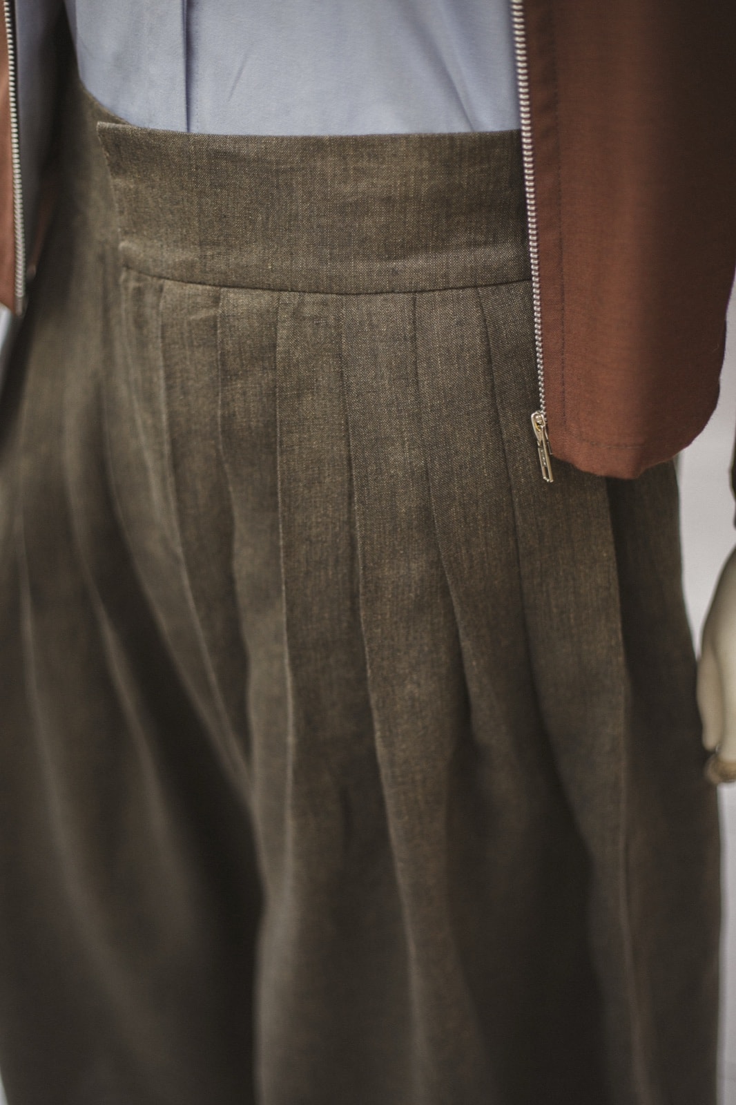 Detalle de las tablas profundas y el cierre lateral del Pantalón Ritual de lino italiano verde alga. Atelier Molina, Buenos Aires