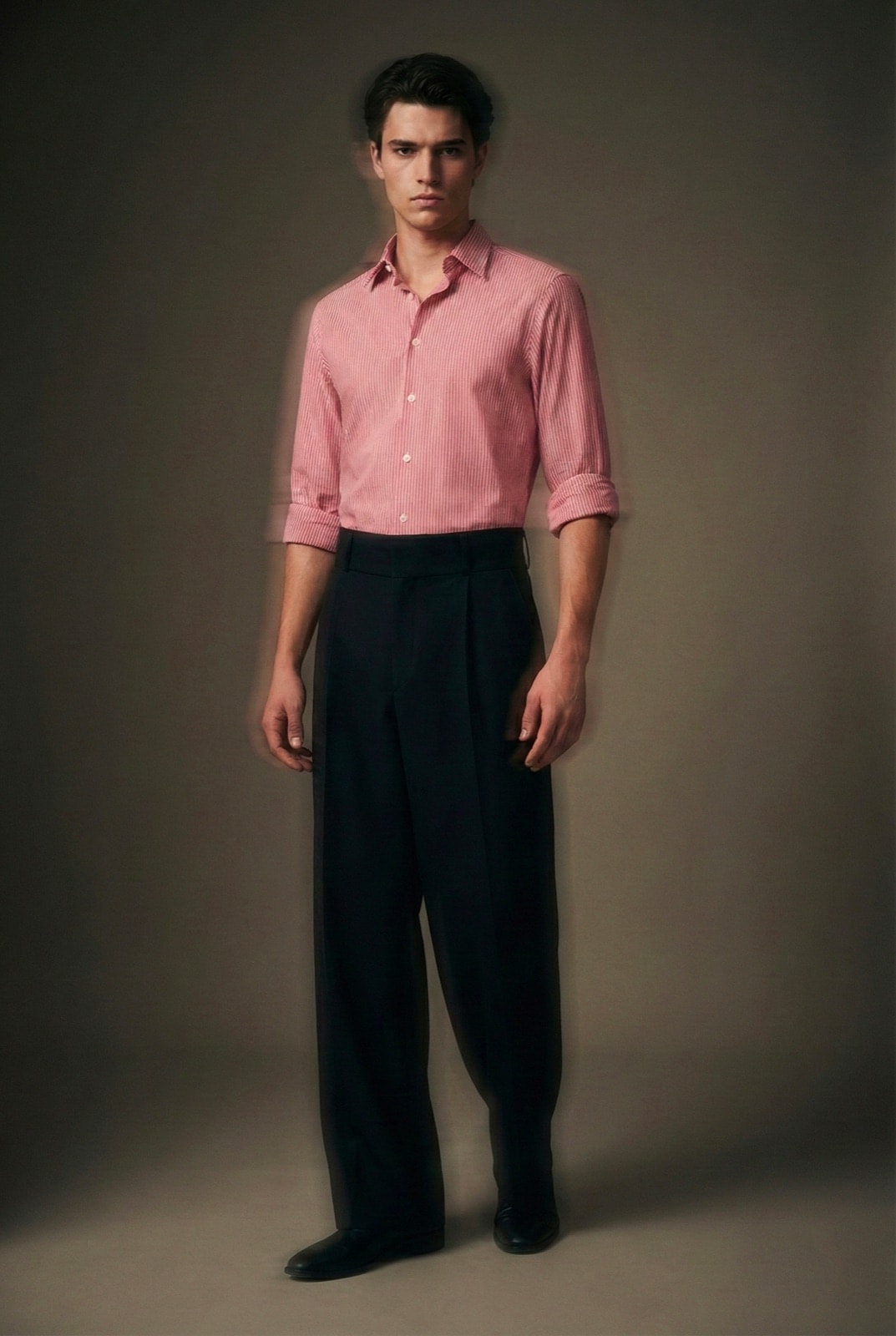 Pantalón Sastrero Molina negro de pierna ancha, vista frontal sobre modelo con camisa a rayas, en un retrato con efecto de movimiento.