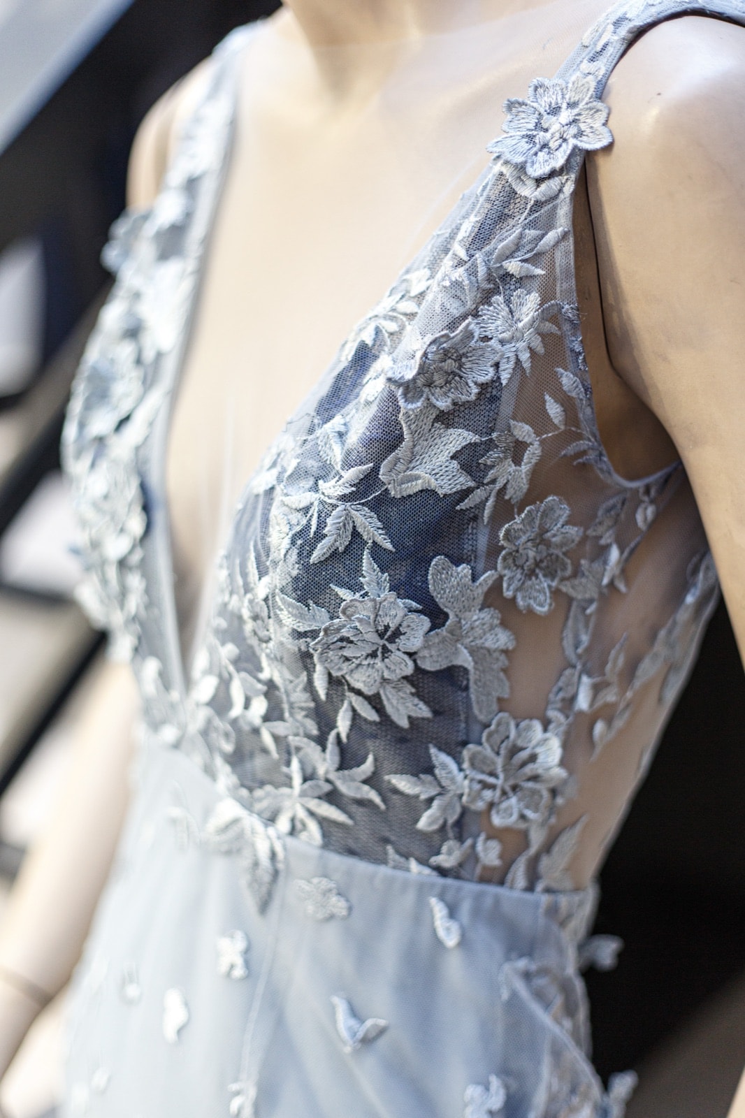 Detalle del bordado floral en relieve del vestido de tul plateado de Atelier Molina, primer plano sobre maniquí.