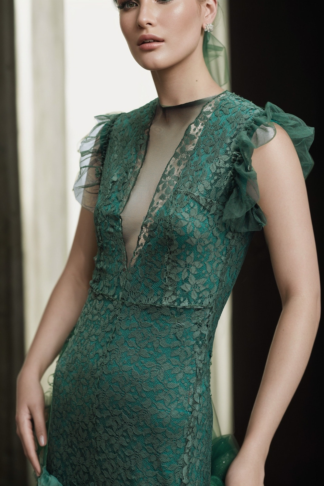 Detalle del escote y los ruffles de tul del Vestido de encaje verde de Atelier Molina, primer plano sobre el hombro.