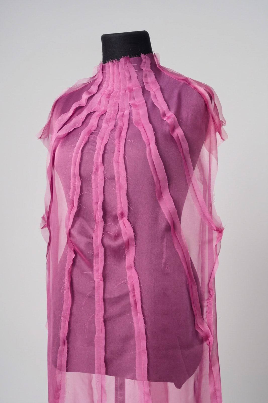 Detalle del frente del vestido de muselina fucsia: costuras a la vista y cuello alto fruncido