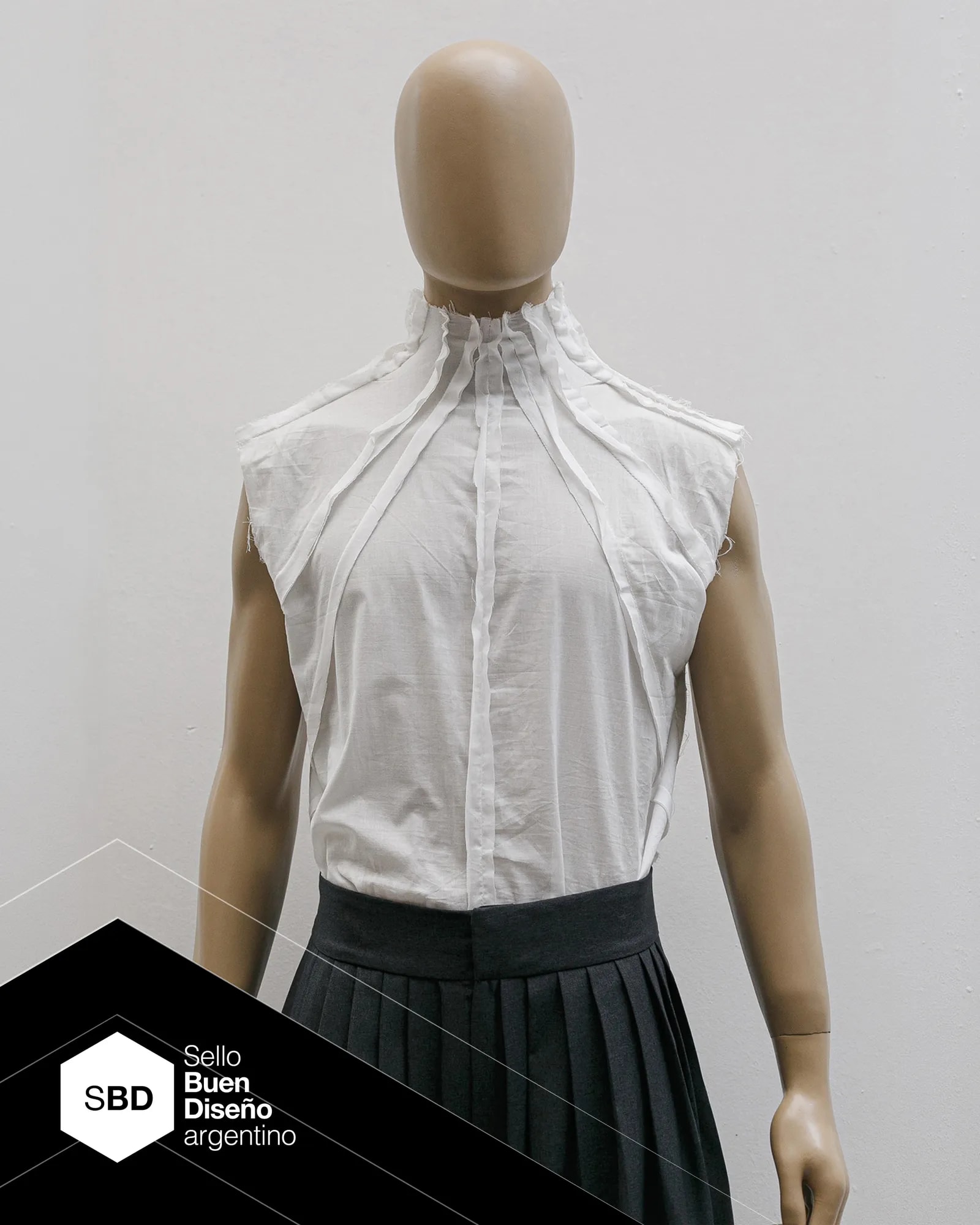 Radial Shirt by Atelier Molina in white cotton poplin, with radial pleats starting at the collar and an exposed seam. Part of the PLIEGO line, Argentine Good Design Seal 2026, made in Buenos Aires.