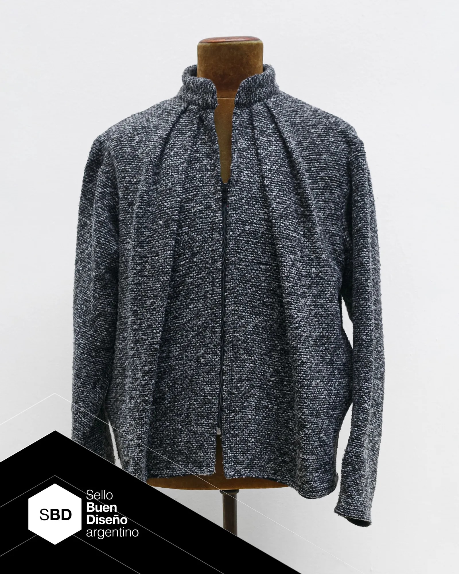 Molina Jacket in grey wool and viscose bouclé, with two front pleats set at 45 degrees. Part of the Atelier Molina PLIEGO line, Argentine Good Design Seal 2026, made in Buenos Aires.