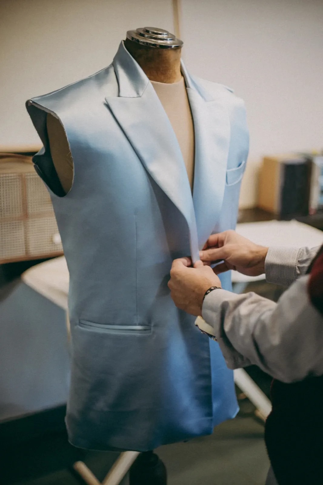 Saco de crepe de seda celeste a medida en proceso sobre maniquí en el atelier, con la sisa aún sin cerrar y la entretela a la vista