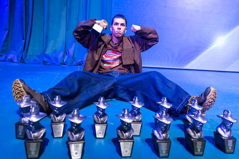 Milo J sentado junto a sus trece Premios Gardel