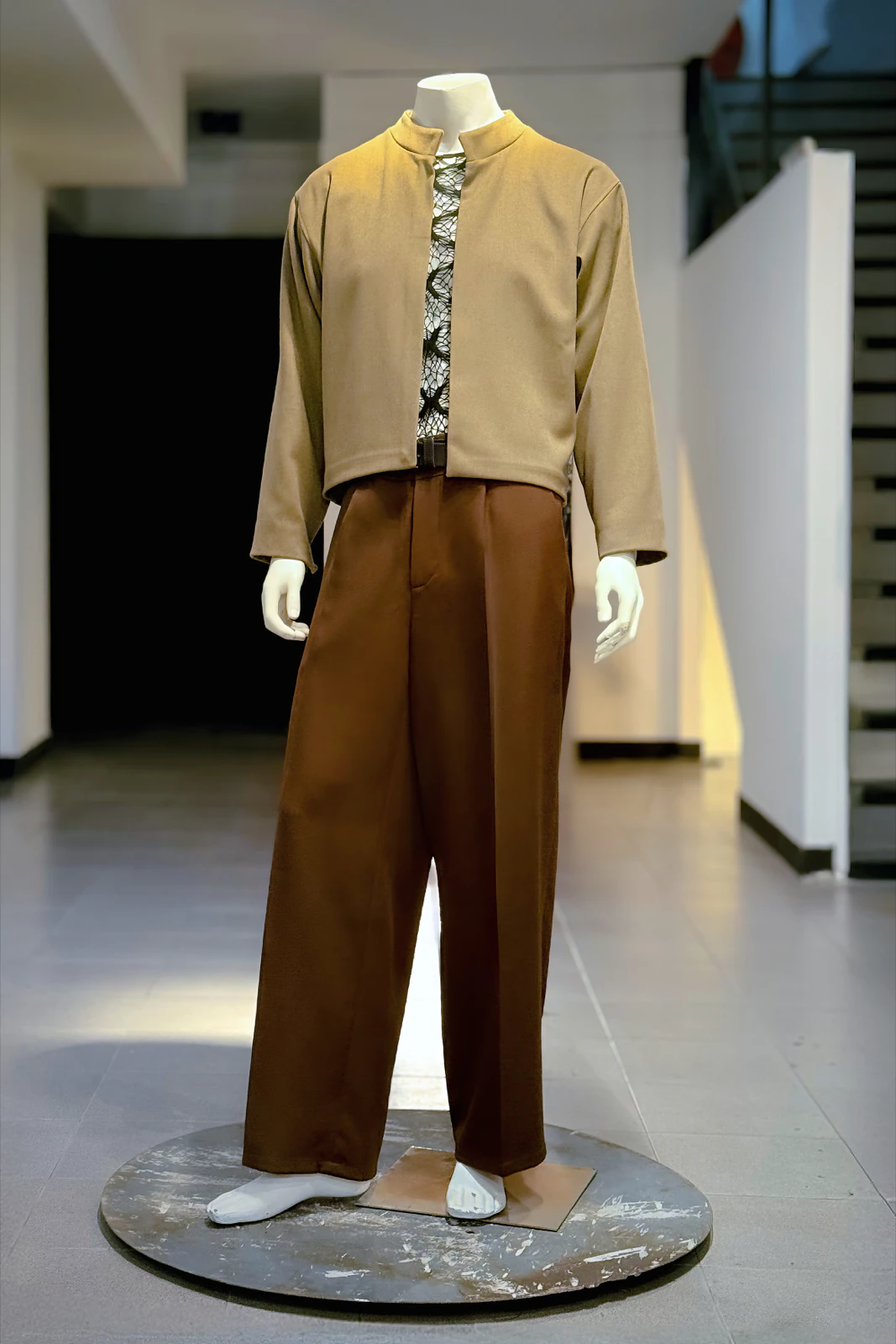 Ale Sergi's look on a mannequin at the Buenos Aires atelier: camel mandarin collar jacket and brown trousers