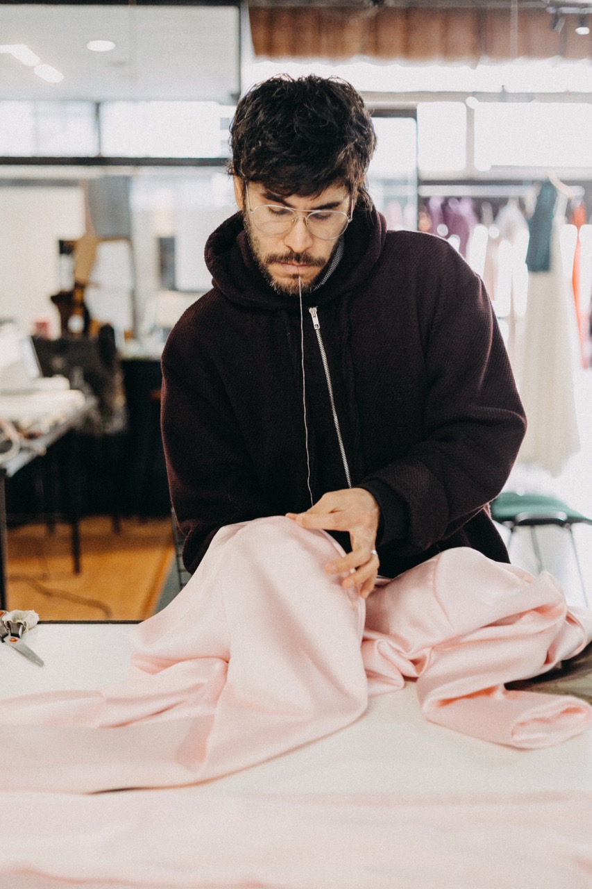 Carlos Molina trabajando el traje rosa de Ian Lucas en el atelier de Buenos Aires